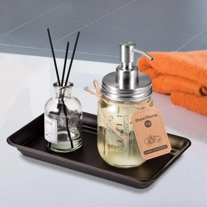Mason jar soap dispenser with silver pump and glass body on Brown and Gold Vanity Trays