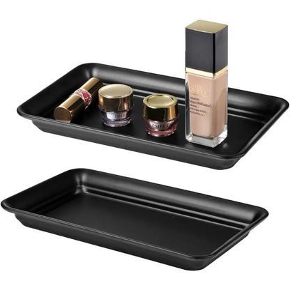 Black matte rectangular vanity tray with gold accents and clear glass cosmetic jars