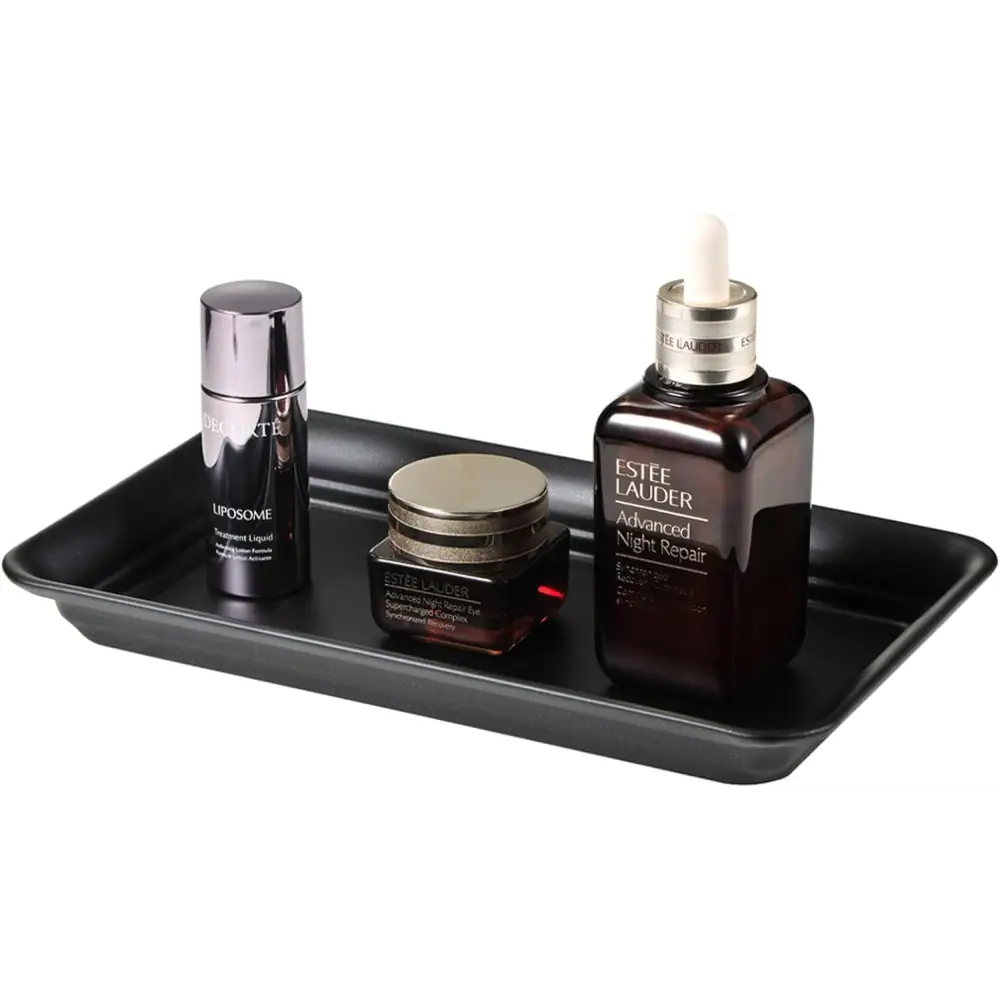 Black rectangular vanity tray with glossy finish holding Estée Lauder skincare products