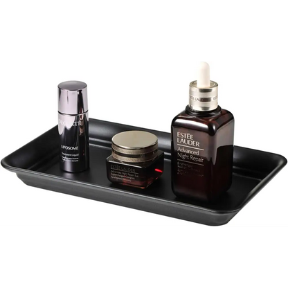 Black rectangular vanity tray with glossy finish holding Estée Lauder skincare products