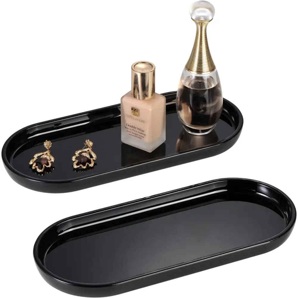 Black oval vanity tray with gold accents and mirrored surface for elegant organization