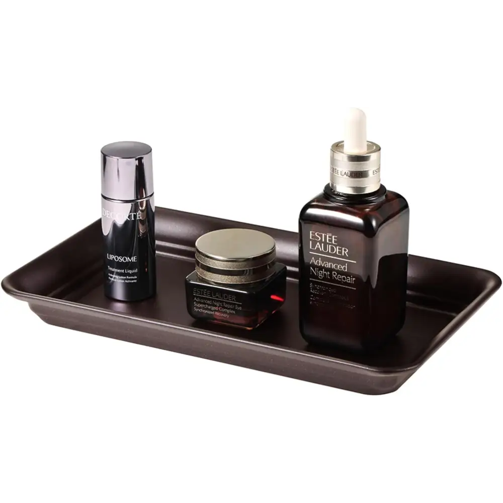 Brown and gold vanity tray with Estée Lauder night repair, Babor cream, and black liposome container