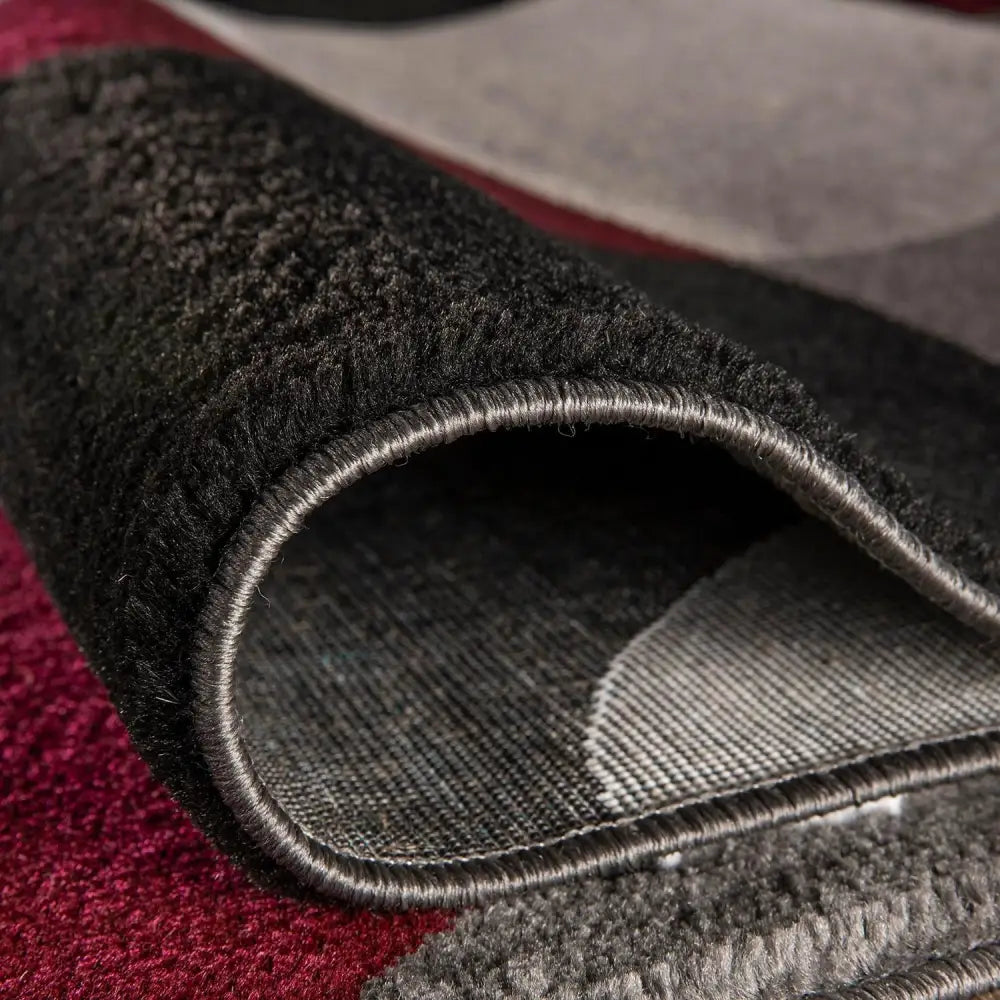 Dark gray textured Circles Abstract Rug with red and black accents in wool or synthetic fiber