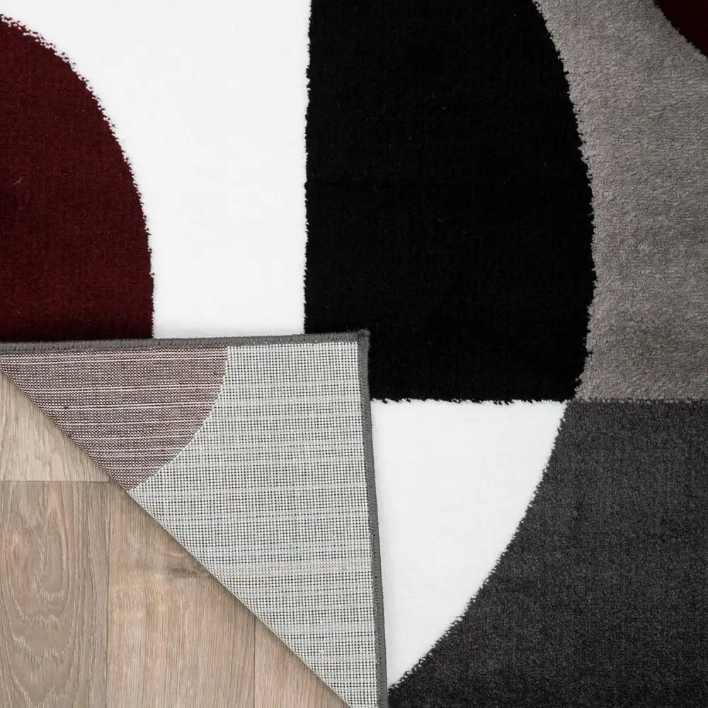 Modern Circles Abstract Rug with black, white, and gray geometric patterns on light wood floor