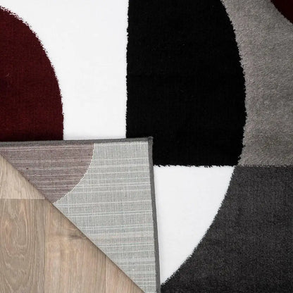 Modern Circles Abstract Rug with black, white, and gray geometric patterns on light wood floor