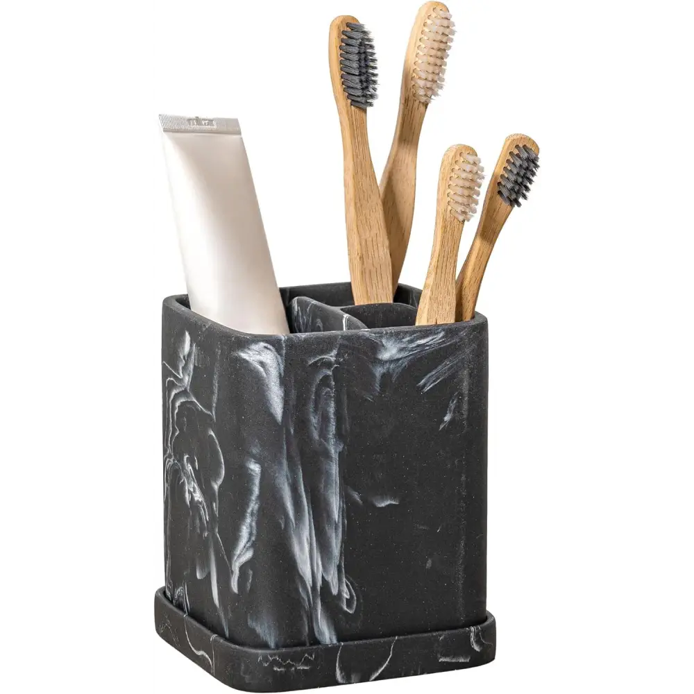 Black marble toothbrush holder with bamboo brushes and cream tube for elegant bathroom decor