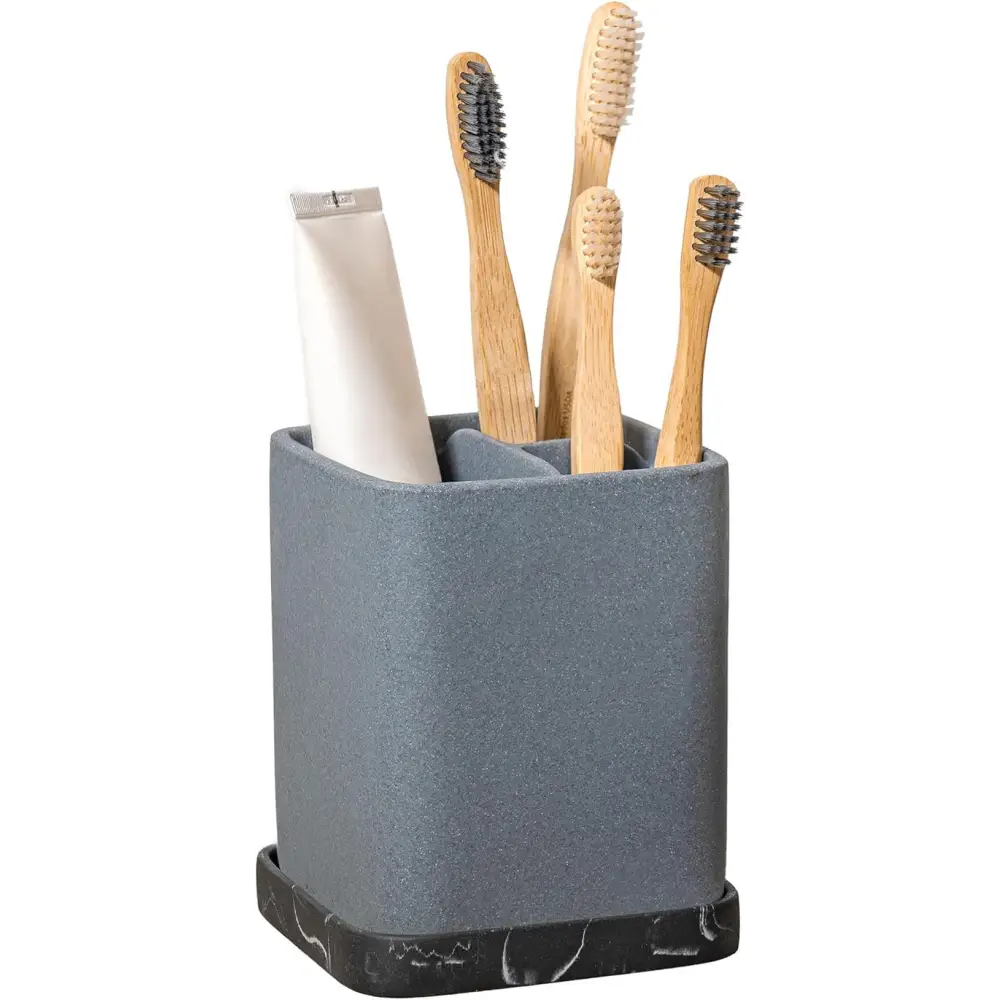 Gray marble toothbrush holder with bamboo brushes and toothpaste tube for bathroom decor