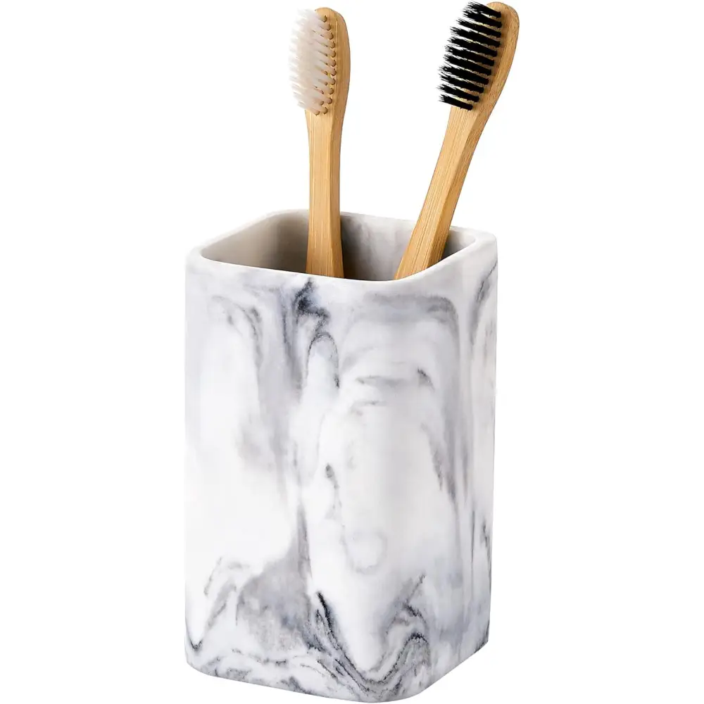 Marble-patterned toothbrush holder with bamboo toothbrushes displayed in a stylish bathroom