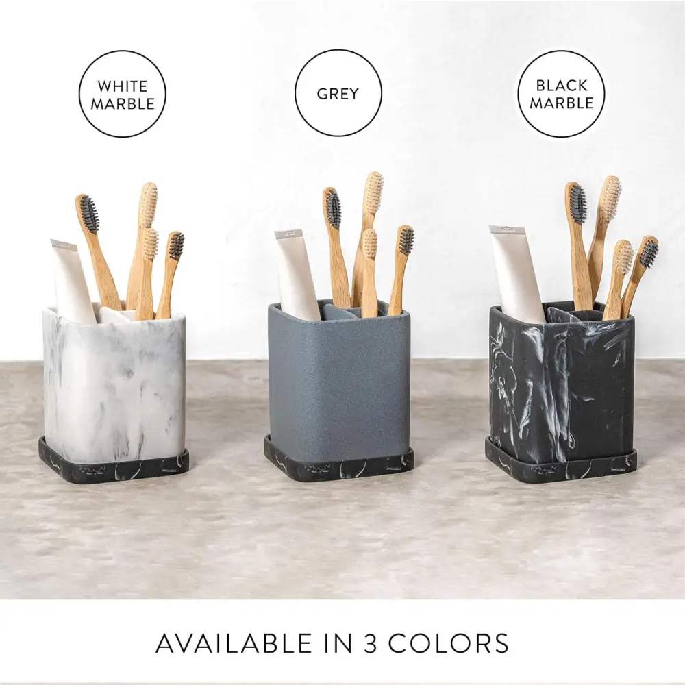 White marble toothbrush holder with black accents and multiple compartments for bathroom organization