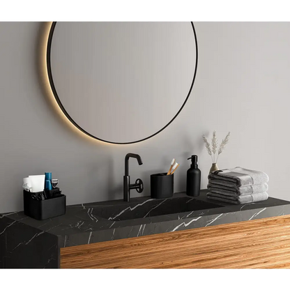 Matte black toothbrush holder set with black marble sink, modern faucet, and soap dispenser against a gray wall