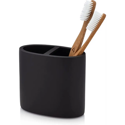 Black matte toothbrush holder with two compartments holding bamboo and white bristle toothbrushes