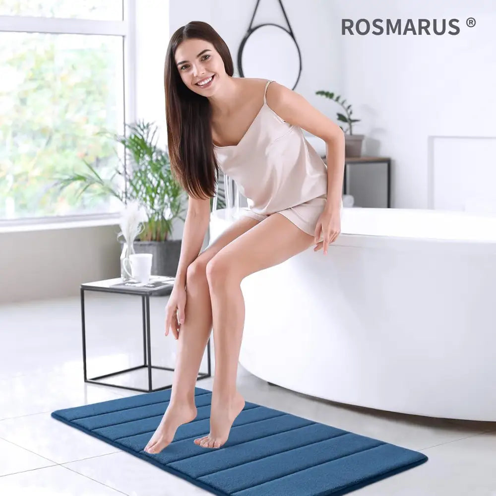 Blue textured memory foam bath mat with Rosmarus logo for comfort and style
